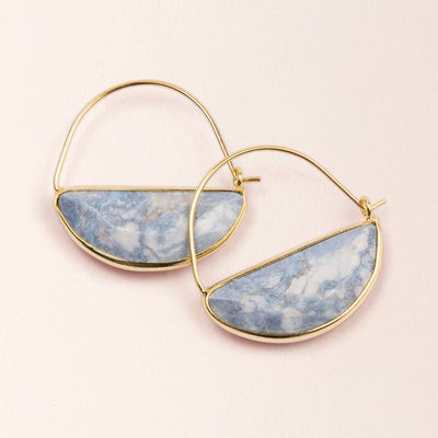 The Stone Prism Hoops feature two minimalist gold hoops set with semi-circular blue and white marbled stones, resembling Blue Howlite, against a light beige background.