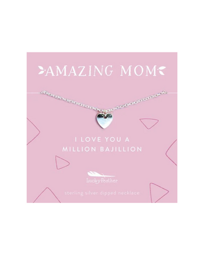 A silver heart necklace displayed on a pink card with the words "Amazing Mom" and "I love you a million bajillion." The necklace features a delicate chain and a small heart charm, perfect for gifting to a cherished mother.