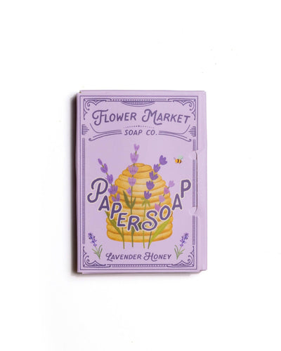 Illustrated packaging of Flower Market Soap Co. Lavender Honey Paper Soap, featuring a charming lavender and honeycomb design with delicate purple flowers and a bee motif.