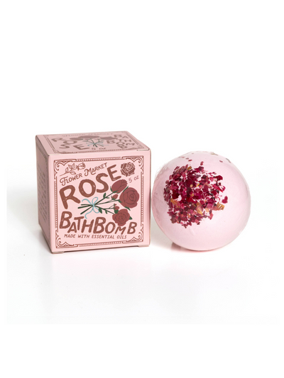 Flower Market Rose Bath Bomb featuring a pink bath bomb adorned with dried rose petals, accompanied by its decorative vintage-inspired packaging with floral accents and essential oil details.