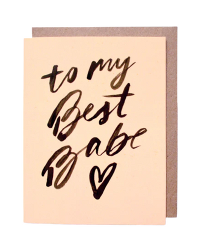 The "To My Best Babe - Card" features black calligraphy with the message on a beige background and a small heart at the bottom. It comes with an eco-friendly brown envelope.
