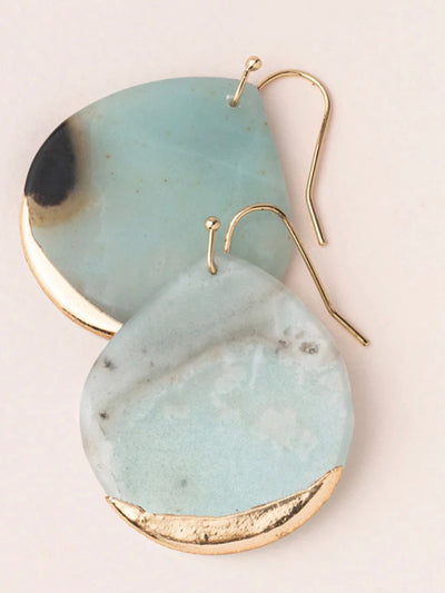 The Stone Dipped Teardrop Earrings in Amazonite and Gold showcase teardrop shapes with pale blue and soft green tones, highlighted by gold edges. These hypoallergenic earrings feature hook fastenings and are stylishly overlapped on a light background, representing minimalistic jewelry elegance.