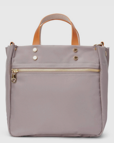 The Joey Nylon Tote in Taupe offers a stylish look with tan handles, a front zip pocket, and gold button accents. Its user-friendly compartments complement the sleek, modern design, making it perfect for everyday use.