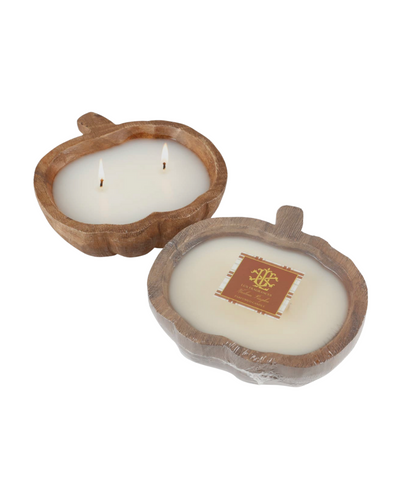 The Wooden Pumpkin Bowl Candle - Small - Fall Chai Tea features two pumpkin-shaped wooden bowls, each filled with white wax and twin wicks to capture the essence of autumn warmth. One candle is adorned with a dark label embellished with gold and white design elements and text, suggesting a delightful cinnamon chai tea fragrance. Both candles are beautifully displayed on a simple white background.